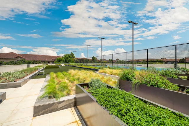 view of home's community with tennis court