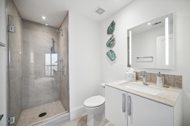 bathroom featuring a shower with door, vanity, toilet, and tile patterned floors