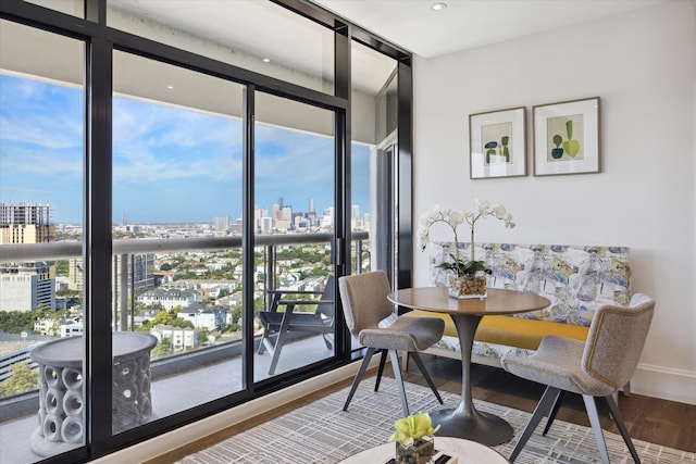 dining area featuring expansive windows, a wealth of natural light, and hardwood / wood-style flooring