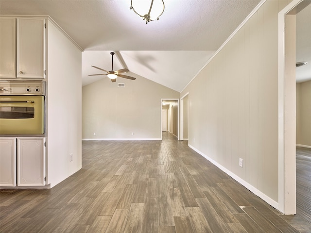 unfurnished living room featuring dark wood-type flooring, ceiling fan, lofted ceiling, and crown molding