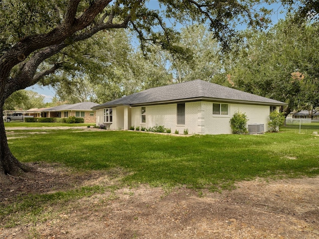 view of property exterior with a lawn and central AC unit