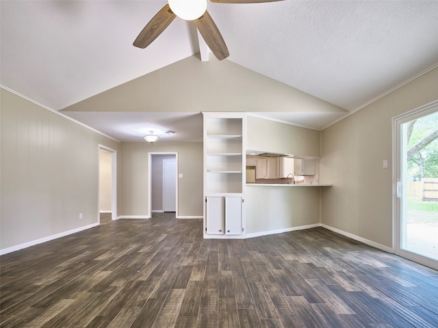 unfurnished living room with a textured ceiling, dark wood-type flooring, sink, ceiling fan, and vaulted ceiling with beams