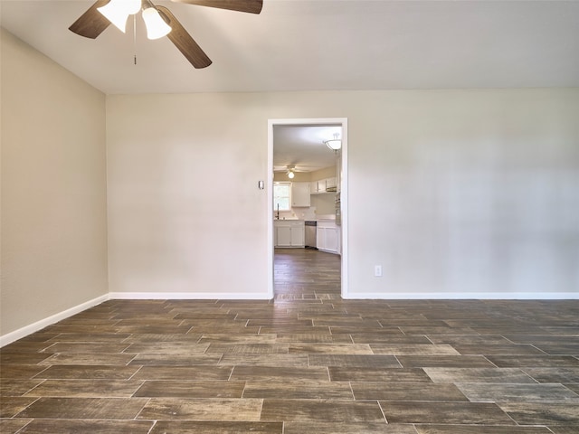 empty room featuring dark wood-type flooring, sink, and ceiling fan