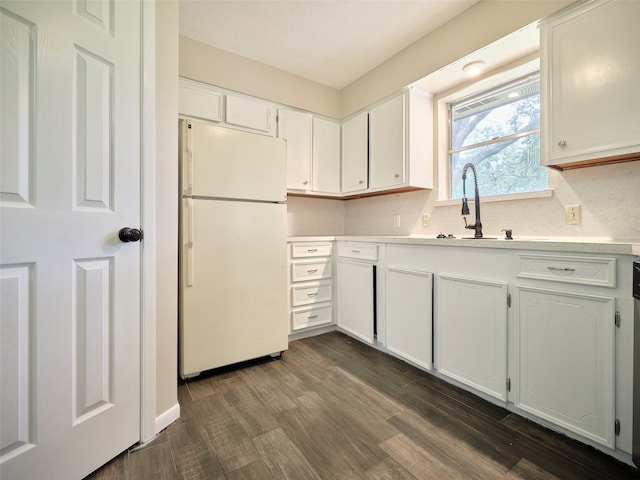 kitchen with white refrigerator, dark hardwood / wood-style floors, white cabinetry, and a textured ceiling