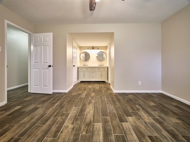 unfurnished living room featuring ceiling fan and dark hardwood / wood-style floors