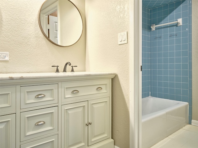 bathroom featuring tiled shower / bath and vanity