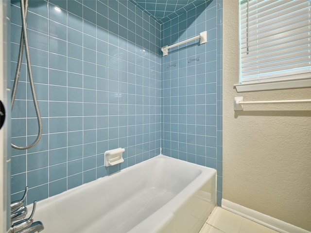 bathroom with tiled shower / bath combo and tile patterned flooring