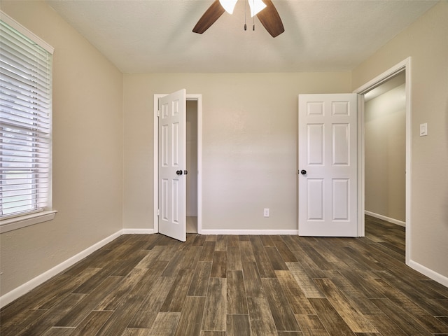 empty room with dark wood-type flooring and ceiling fan