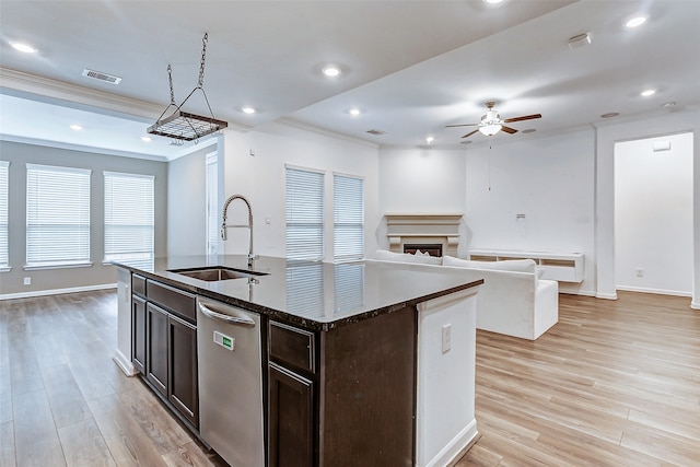 kitchen featuring sink, light hardwood / wood-style floors, an island with sink, and stainless steel dishwasher