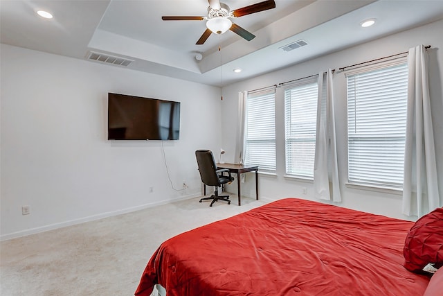 bedroom with carpet flooring, a raised ceiling, and ceiling fan