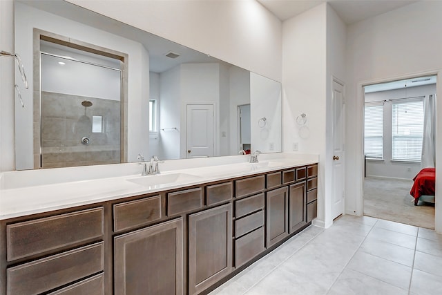 bathroom featuring tiled shower, vanity, and tile patterned flooring