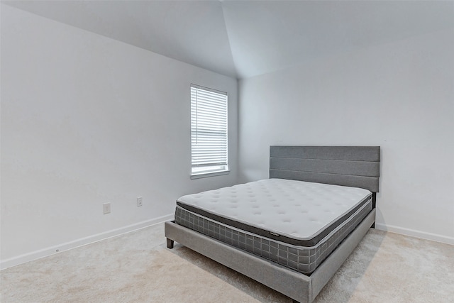 bedroom featuring lofted ceiling and light colored carpet