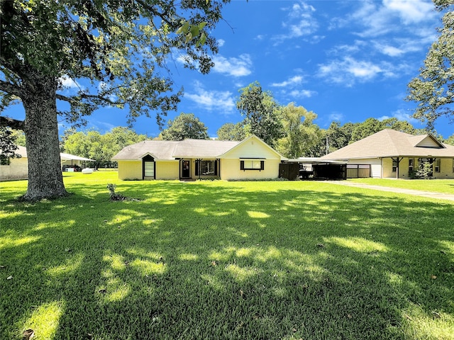 ranch-style home with a carport and a front lawn