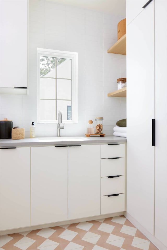 kitchen featuring white cabinetry and sink