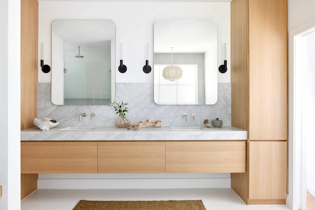 bathroom with vanity, tasteful backsplash, and a tile shower