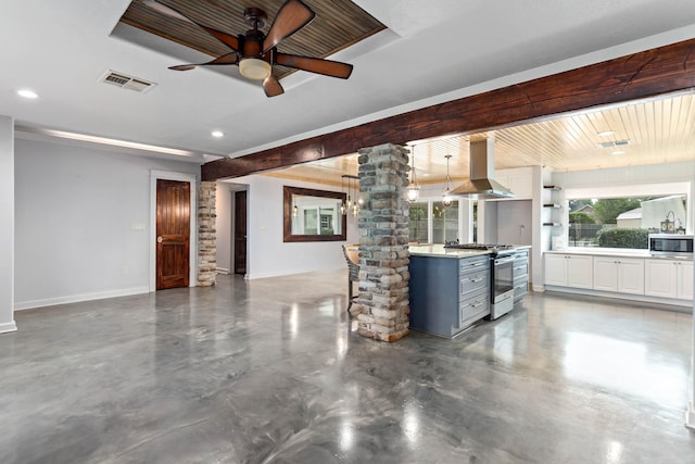 unfurnished living room featuring ceiling fan and decorative columns