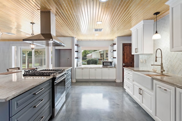 kitchen with decorative light fixtures, island range hood, stainless steel appliances, white cabinetry, and light stone counters