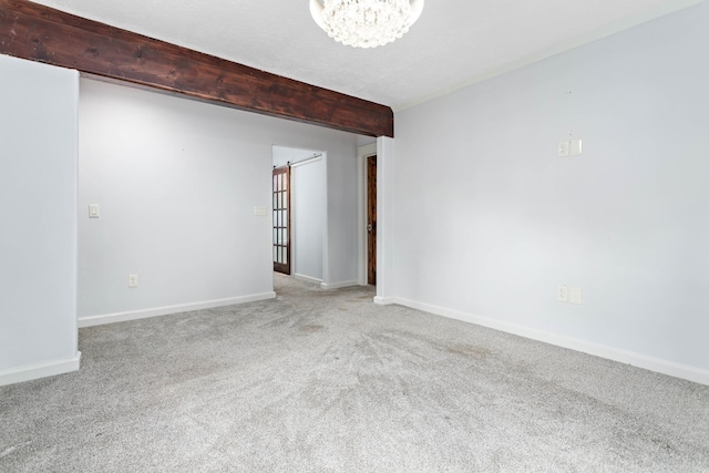 carpeted empty room featuring an inviting chandelier and beam ceiling