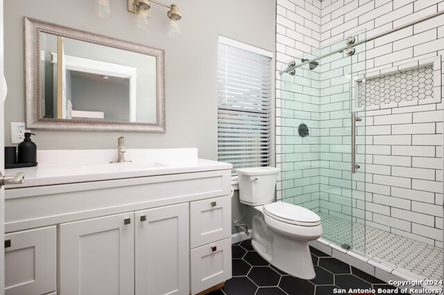 bathroom featuring vanity, toilet, tile patterned flooring, and a shower with door