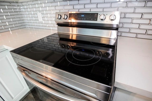 details featuring decorative backsplash and stainless steel electric range oven