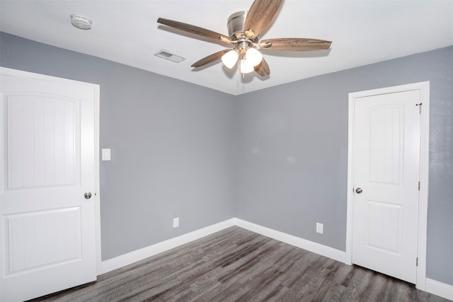 spare room with dark wood-type flooring and ceiling fan