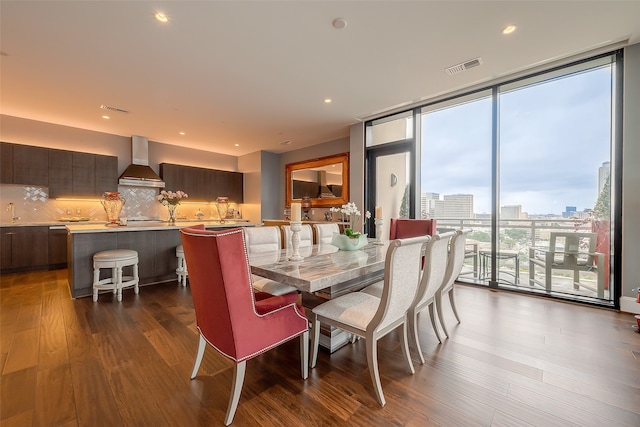 dining room with dark wood-type flooring and a wall of windows