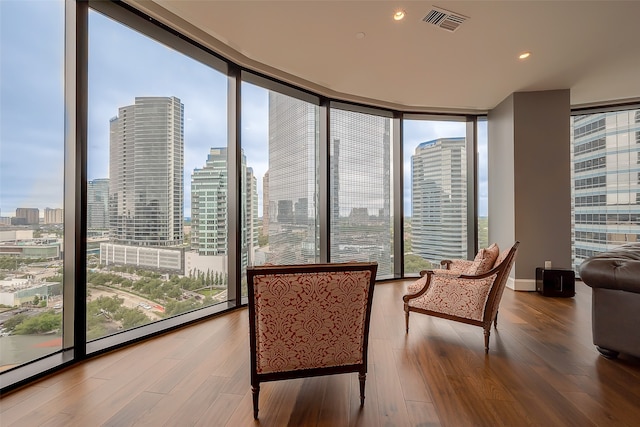 sitting room featuring floor to ceiling windows and hardwood / wood-style flooring