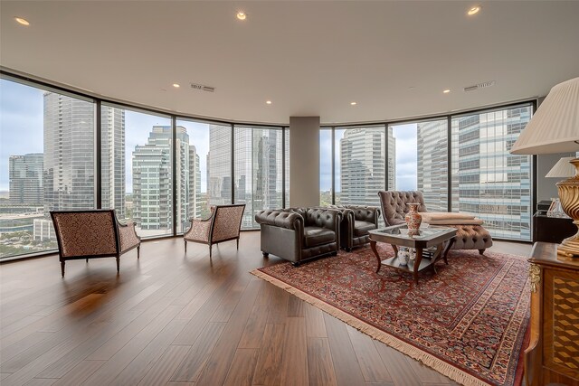 living room with a wall of windows and hardwood / wood-style flooring