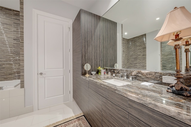 bathroom featuring vanity, a tub, and tile patterned flooring