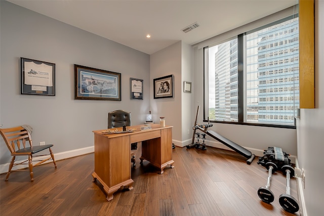 office featuring dark wood-type flooring and a healthy amount of sunlight