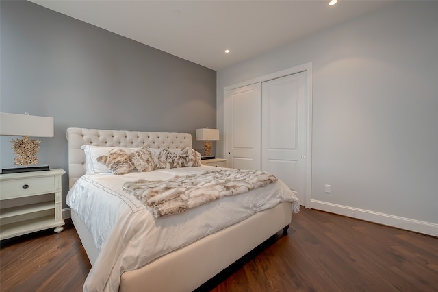 bedroom with dark hardwood / wood-style flooring and a closet