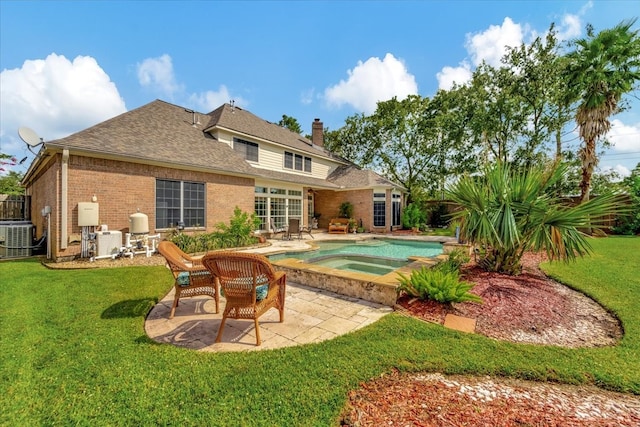 rear view of house with central AC unit, a patio area, a yard, and an in ground hot tub