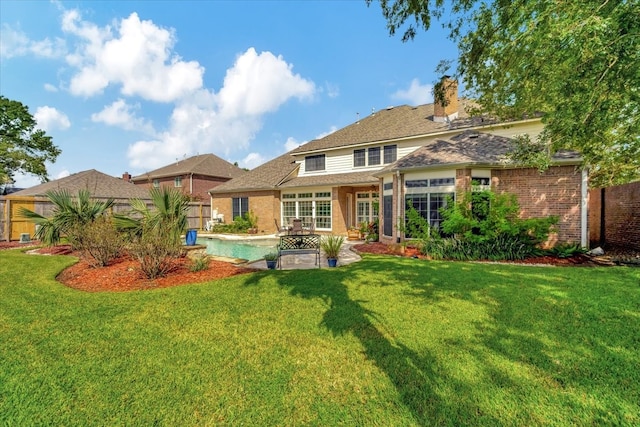 back of house with a lawn and a patio