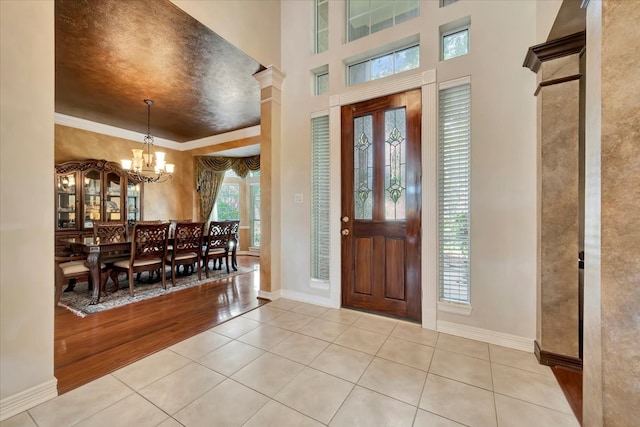 foyer entrance with ornamental molding, a chandelier, and light hardwood / wood-style floors