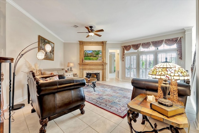 living room featuring crown molding, light tile patterned floors, ceiling fan, and a large fireplace