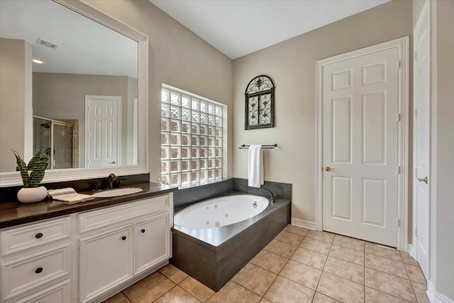 bathroom with tile patterned flooring, independent shower and bath, and vanity