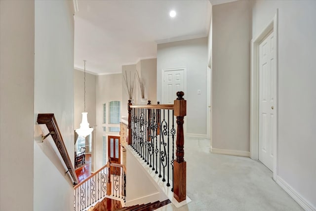 staircase with crown molding and carpet flooring