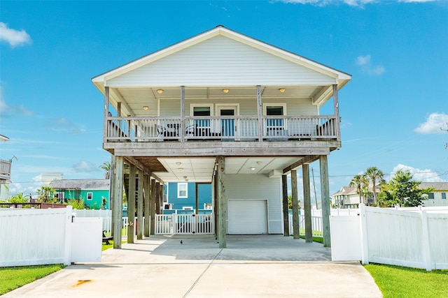 beach home featuring a garage, covered porch, and a carport