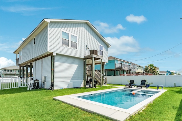 rear view of property featuring a pool side deck and a yard