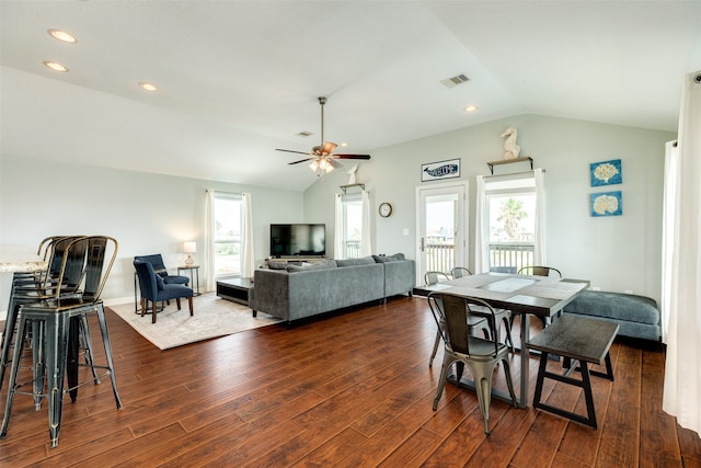 dining space with dark wood-type flooring, ceiling fan, and vaulted ceiling