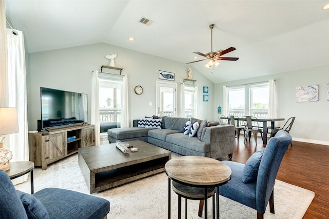 living room featuring ceiling fan, light wood-type flooring, and vaulted ceiling