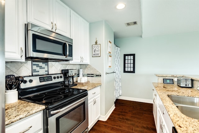 kitchen featuring dark hardwood / wood-style flooring, appliances with stainless steel finishes, sink, light stone counters, and white cabinets