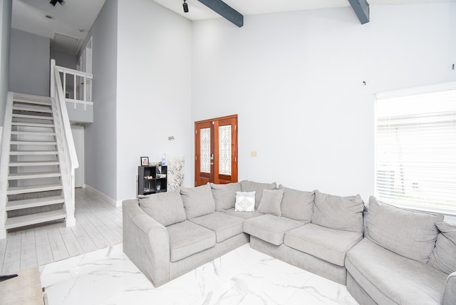 living room with high vaulted ceiling, beamed ceiling, and light hardwood / wood-style flooring