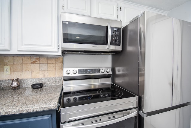 kitchen featuring appliances with stainless steel finishes, white cabinetry, blue cabinets, and backsplash