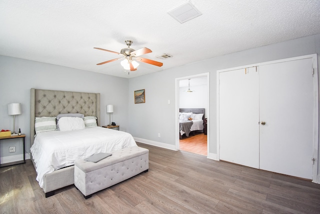 bedroom with a closet, hardwood / wood-style floors, and ceiling fan