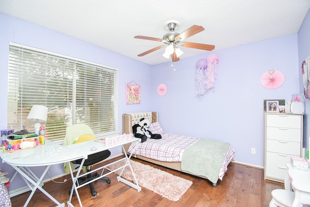 bedroom with hardwood / wood-style floors, a textured ceiling, and ceiling fan