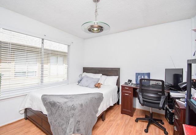 bedroom with light hardwood / wood-style flooring and a textured ceiling