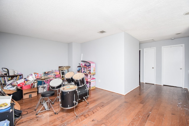 rec room with a textured ceiling and wood-type flooring