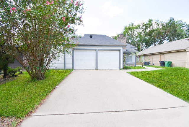 view of front of house with a front yard, a garage, and central AC unit