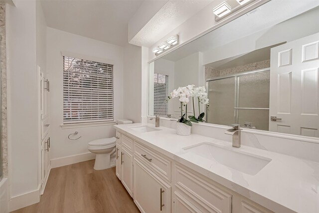 bathroom with walk in shower, vanity, toilet, and hardwood / wood-style flooring